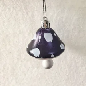 Close-up of a purple painted mushroom ornament with white polka dots for Christmas
