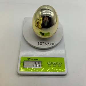 Detalle de huevo de Pascua de plástico dorado de 10x7,5cm siendo pesado en una báscula