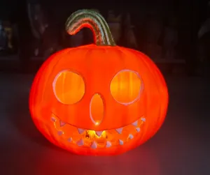 Glowing Halloween plastic pumpkin lantern with warm LED light for holiday atmosphere