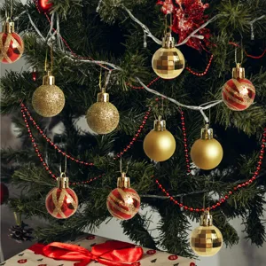 Close-up detail of gold and red mini Christmas balls hanging on a festive tree branch