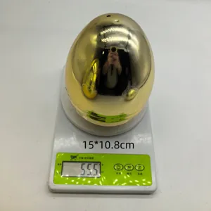 Detalle de huevo de Pascua de plástico dorado en báscula con peso de 55,5g y medidas
