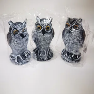 Detailed view of three lifelike plastic owl bird deterrents in protective plastic wrap.