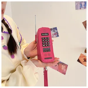 Detailed handheld view of a creative retro pink brick phone shaped handbag with keypad