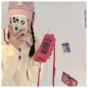 Detailed view of a creative pink retro cell phone shaped crossbody bag held by a model