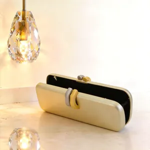 Dettaglio di una lussuosa pochette da sera dorata con una chiusura a incastro dal design unico