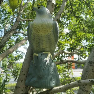Statue de leurre d'aigle réaliste pour la protection du jardin sur une branche d'arbre.