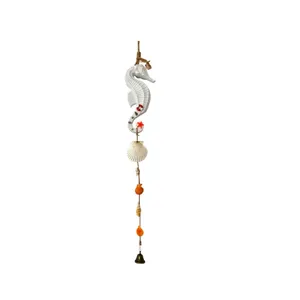Detail view of a Mediterranean seahorse wind chime with shells and a small bell.