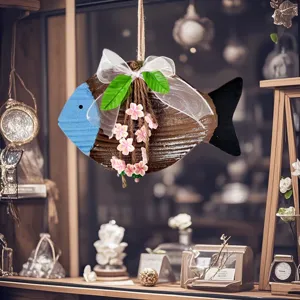 Detail view of a Mediterranean wooden fish ornament with white bow and pink flowers.