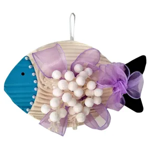 Close-up detail of a Mediterranean fish hanging ornament with purple bow and white pearls