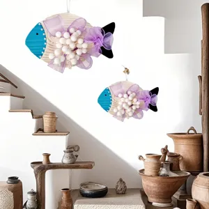 Mediterranean fish hanging decor with purple bows and white pom-poms on wall.