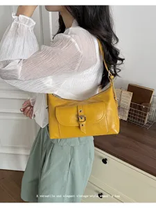 Close-up of vintage yellow oil wax leather underarm bag with buckle pocket