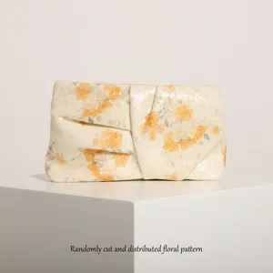 Dettaglio clutch in paillettes con stampa floreale casuale, elegante accessorio da sera.