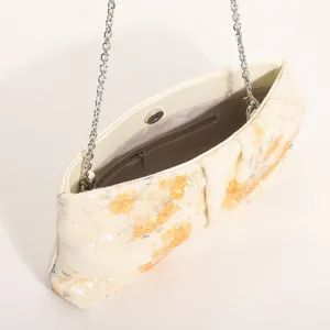 Dettaglio borsa da sera plissettata con paillettes ricamo floreale e catena metallica.