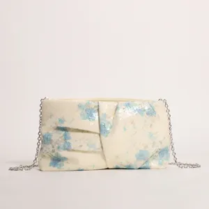 Dettaglio della borsa pochette da sera con paillettes floreali e catena argento.