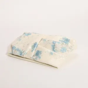Primo piano dettagliato della elegante borsa a pochette plissettata con fiori e paillettes.