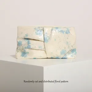 Vista dettagliata della pochette di paillettes con design plissettato e motivo floreale casuale.