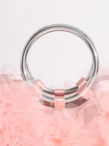 Detail shot of a sweet pink ruffle handbag featuring a sleek silver ring handle