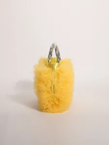 Macro view of a vibrant yellow ruffled mesh handbag showing delicate pleated fabric details