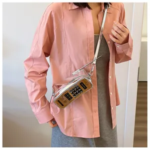 Detailed view of nostalgic mobile phone shaped crossbody bag on a model wearing pink shirt