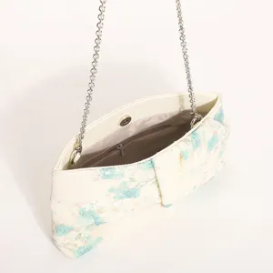 Vista dettagliata della borsa a tracolla da donna con paillettes floreali, catena e design plissé.