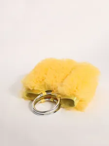 Detailed view of yellow pleated mesh handbag featuring elegant silver metallic ring handles