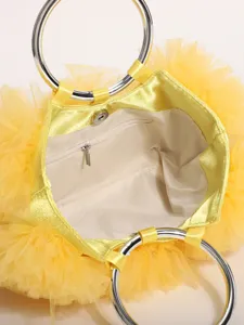 Detail view of yellow ruffled tulle handbag interior with silver ring handles.