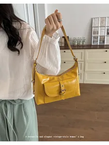 Macro detail view showing the yellow oil wax leather texture and front pocket design
