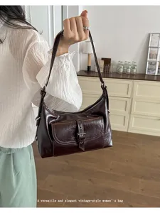 Vintage oil wax leather shoulder bag with front buckle pocket shown in a lifestyle setting