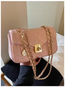 Close-up of pink quilted crossbody bag with gold chain and floral charm detail.