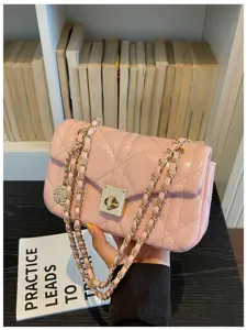 Detailed view of a pink quilted oil-finish flap bag with a gold-tone chain strap.