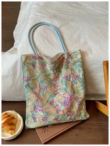 Detailed view of geometric sequin embroidery on a stylish tote bag in a lifestyle setting