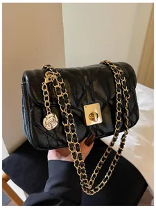 Detailed view of black quilted oil leather bag with camellia charm and gold chain