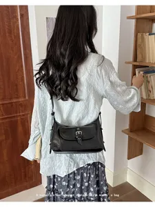 Stylish vintage black oil wax leather shoulder bag with pocket detail worn by model