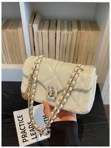 Detailed view of the cream quilted leather flap bag with elegant chain strap.