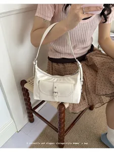 Detail view of a vintage white oil wax leather underarm shoulder bag worn by a model