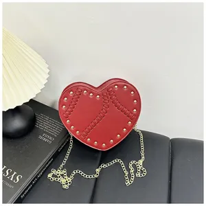 Detaillierte Ansicht der roten herzförmigen Handtasche mit Nieten und goldener Kette