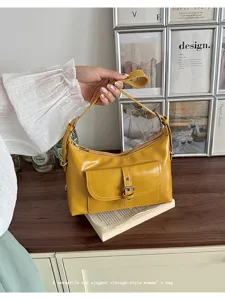 Close-up of vintage yellow oil wax leather underarm bag with buckle pocket