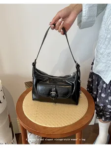 Detailed view of a vintage-style black oil wax leather underarm bag with pocket design