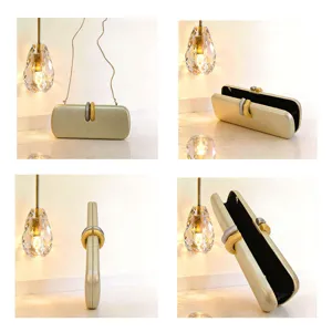 Elegante pochette da sera dorata con tracolla a catena e chiusura in metallo bicolore.
