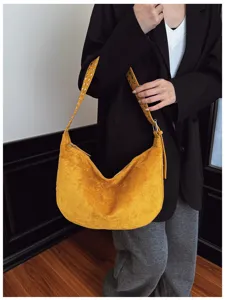Retro yellow suede hobo shoulder bag for women, stylish underarm bag with grommet strap.