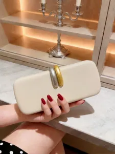 Vista dettagliata della pochette da sera crema con chiusura intrecciata oro e argento