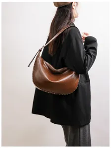 Detailed view of the stylish brown hobo dumpling bag featuring chic rivet trim and spacious design.