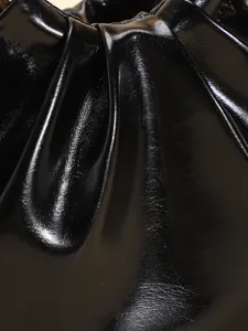 Gros plan détaillé sur la texture plissée en similicuir noir brillant d'un sac à main rétro