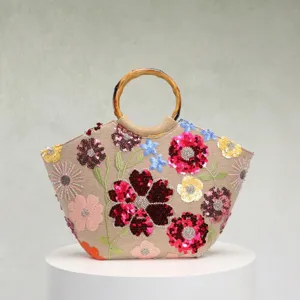 Nahaufnahme der floralen Paillettenstickerei und des Bambusgriffs an der Leinen-Tote-Bag