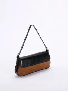 Detailansicht einer zweifarbigen baguette-schultertasche aus schwarzem leder und braunem wildleder