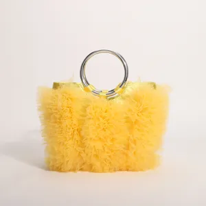 Detail of yellow ruffled tulle handbag featuring metallic silver ring handle and pleats.