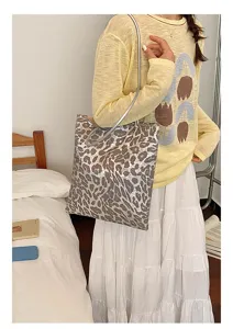 Detail view of a stylish large capacity leopard print sequin tote bag on a model