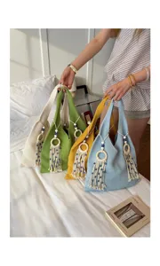Bunte Strick-Schultertaschen im Boho-Stil mit Quasten für den sommerlichen Strandurlaub.