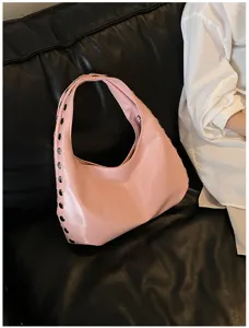 Close-up of pink shiny PU underarm bag with punk-style metal stud decorations.