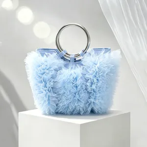 Detailed view of the ruffle tulle pleats and silver metal handle on a blue handbag.